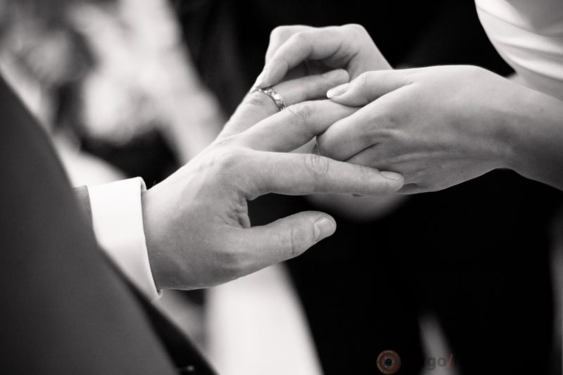 Bride putting ring on groom finger